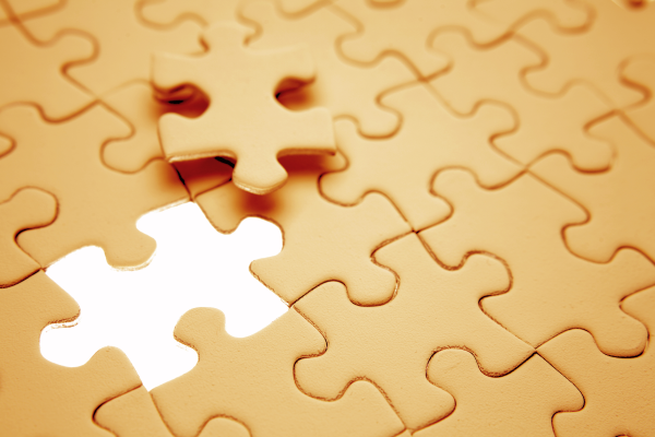 wooden puzzle pieces fit together with a single piece missing