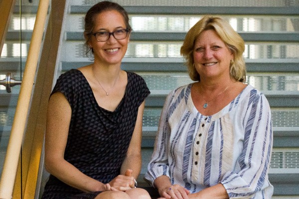 Sarah Wiehe and Sharon Moe pose on the steps of the HITS building in Downtown Indianapolis.